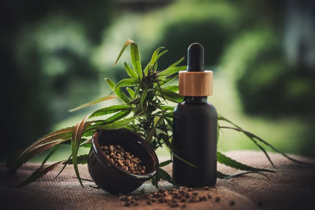 cbd flower with tincture bottle and seeds